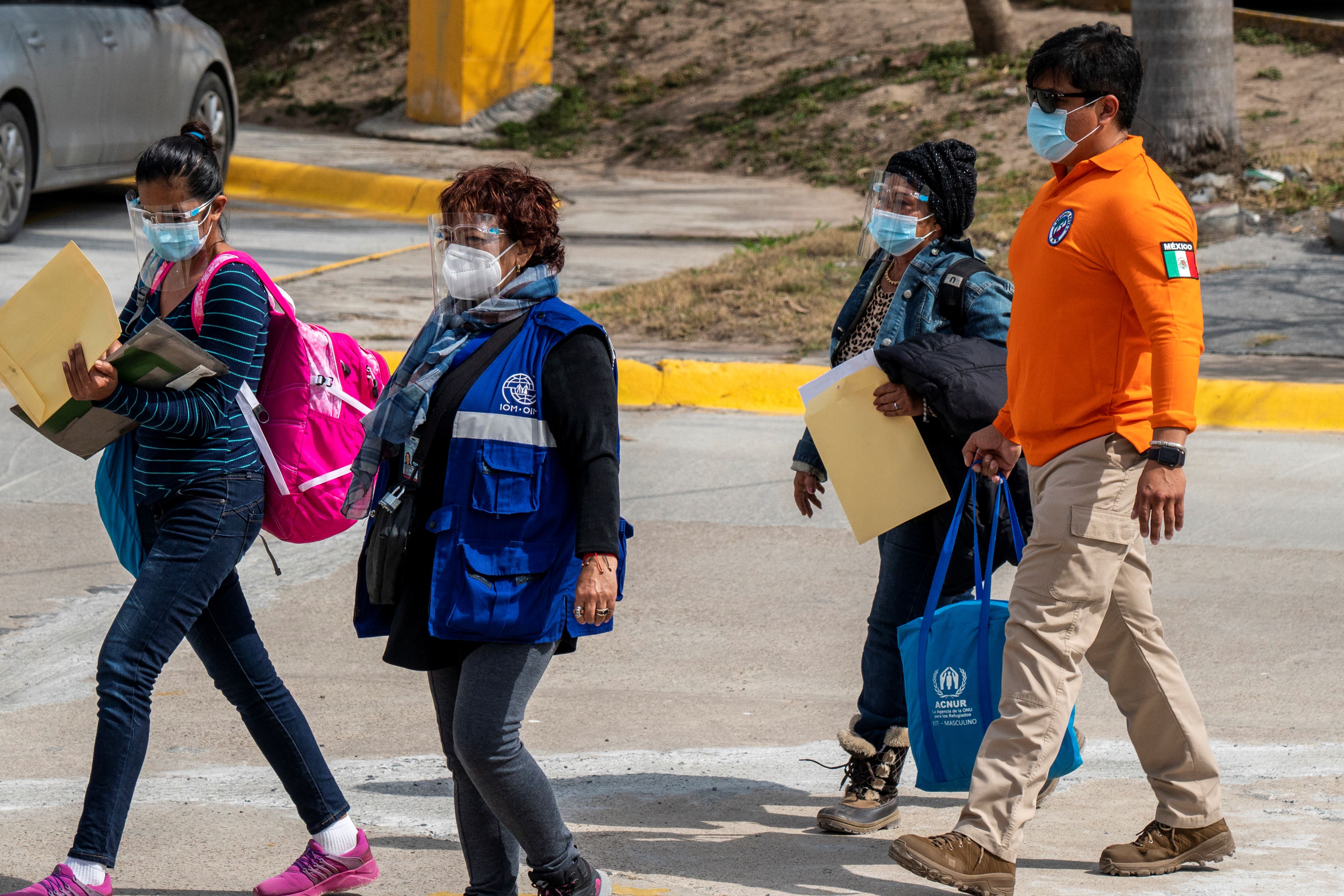 一群人走在街上：奥妮莉亚·阿隆索与墨西哥国家移民研究所和联合国的官员过境。