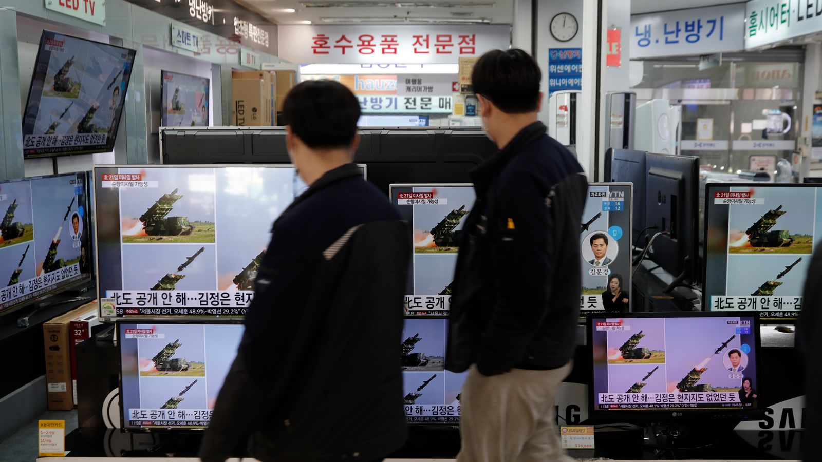 一个站在商店前的人：韩国人观看有关朝鲜在汉城发射导弹的新闻报道。 图片：AP
