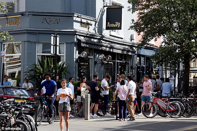 一群人在城市的街道上骑自行车：UK Hospitality警告说，如果部长们不因封锁而坚持路线图，则将关闭30,000家酒吧，酒吧和餐馆。 图为：去年人们在Wandsworth Common喝酒的人